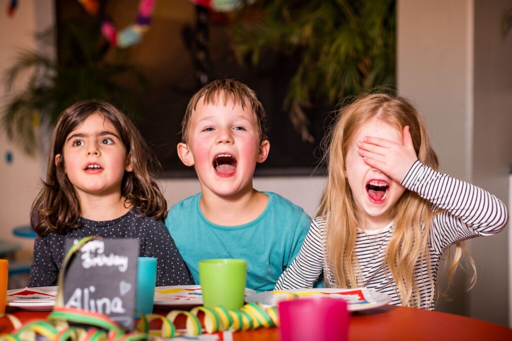 Drei Kinder sitzen an einem Tisch